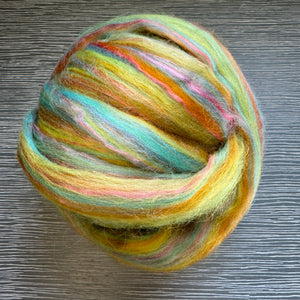 Multicolored yarn ball on a wooden surface